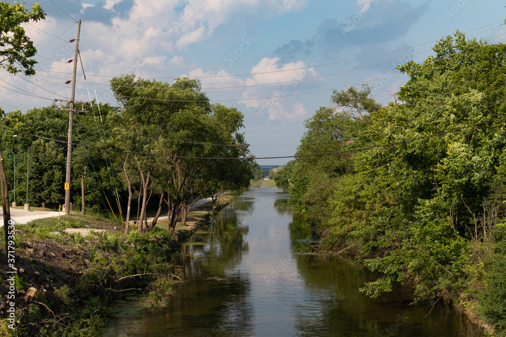Obraz premium Canal in Downtown Lemont Illinois with Green Trees during Summer