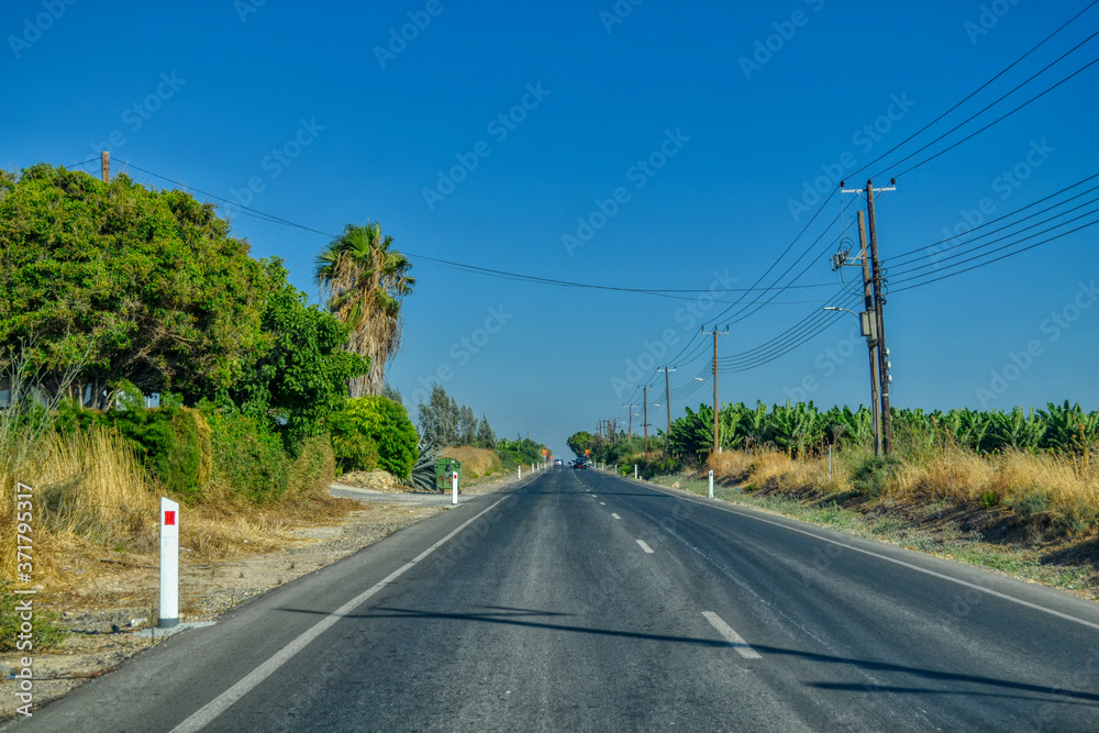 Asphalt road through the rural areas of Paphos, Cyprus. A road along the Mediterranean coast leading to the city center. Asphalt road through the rural areas of Paphos, Cyprus. A road along the Mediterranean coast leading to the city center.