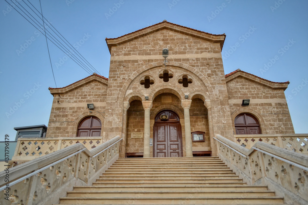 Paphos, Cyprus - July 23, 2019. Modern orthodox church built in the Romanesque style in the city of Paphos, Cyprus.  A beautiful religious temple with an arch in front of the entrance.