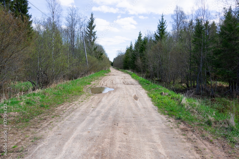 A dirt road that goes into the distance in the village.