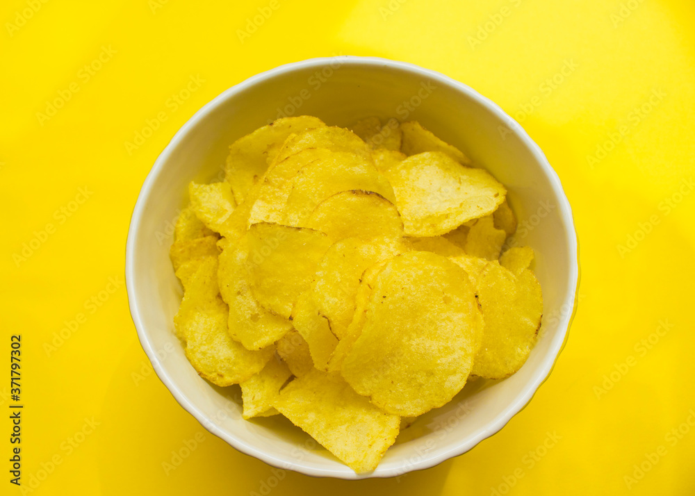 plate with chips on a yellow background top view. junk food