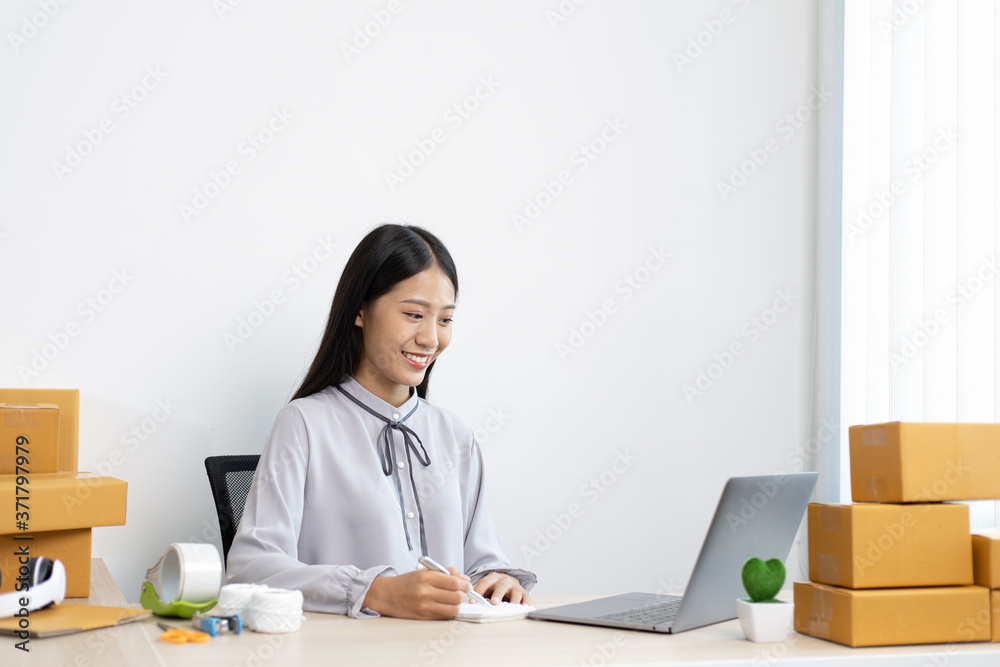 Young Asian woman is selling products online and is confirming an order from a customer. Young Asian woman is selling products online and is confirming an order from a customer.