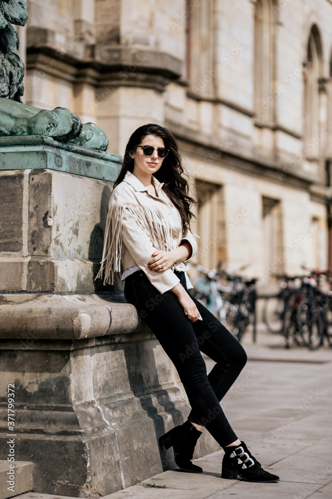 Beautiful attractive woman wearing beige fashion jacket and black glasses outdoor