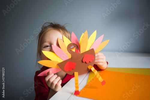 paper craft for kids. DIY Turkey made for thanksgiving day. create art for children. girl playing with a toy