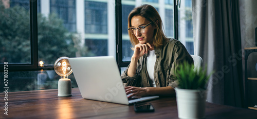 Young woman working with a laptop. Female freelancer connecting to internet via computer. Businesswoman at work
