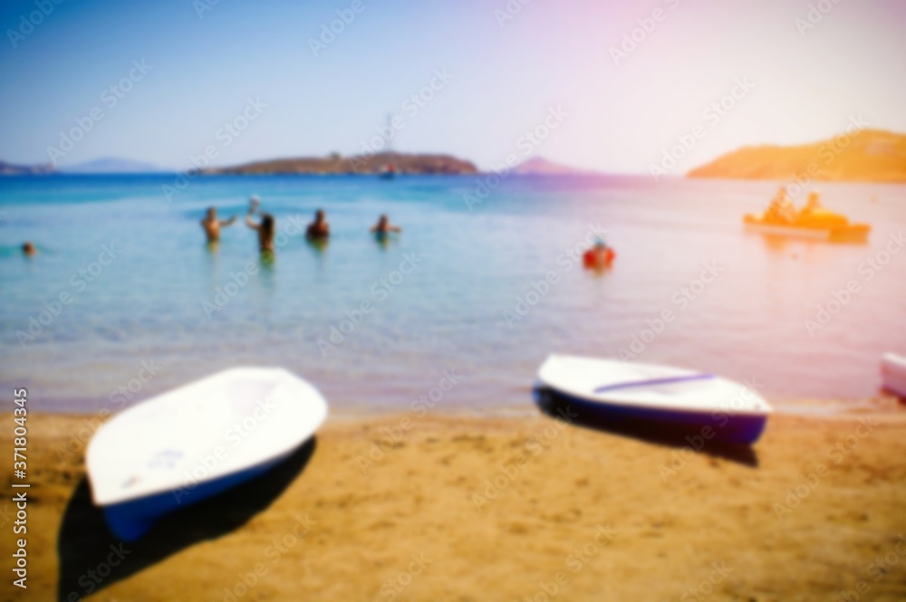 People swimming, canoe cayak on the beach, summer holidays on Greek island, blurred background.