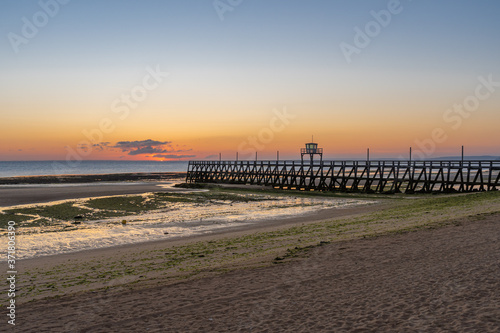 Luc Sur Mer, France - 08 04 2020: Sunrise over Le Havre and Luc-Sur-Mer pontoon from the beach