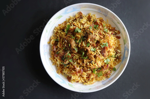 Mutton Biryani or Lamb Pulao. Garnished with fried onion & chopped coriander. Biryani is a famous Spicy non-vegetarian dish of India. Goat meat cooked along with Basmati rice & spices.