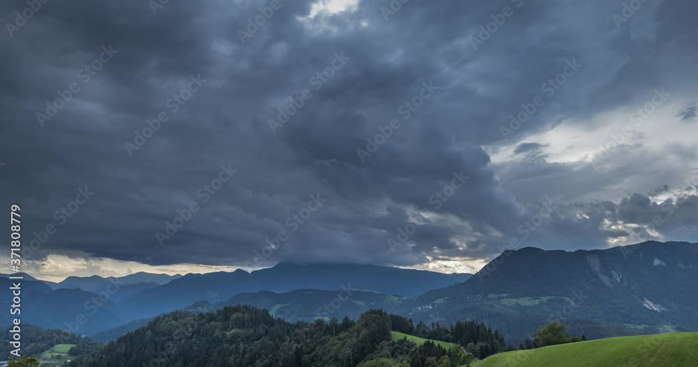 Time lapse storm clouds moving over beautiful countryside covered with trees. Hills and mountains in Slovenia. Dramatic clouds in the sky. Wide, static, 4K Time lapse storm clouds moving over beautiful countryside covered with trees. Hills and mountains in Slovenia. Dramatic clouds in the sky. Wide, static, 4K