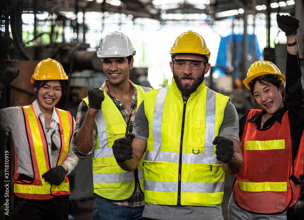 Technicians and Engineer workers with hardhat or helmet, vest showing hands coordination and raising fist smiling for successful working in workplace of industry Factory/Teamwork co-workers Technicians and Engineer workers with hardhat or helmet, vest showing hands coordination and raising fist smiling for successful working in workplace of industry Factory/Teamwork co-workers