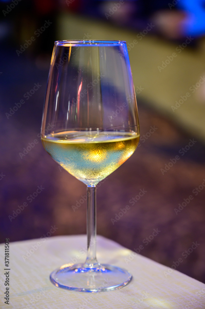 Obraz premium Glass of cold dry white wine served outdoor in cafe at night in Italy