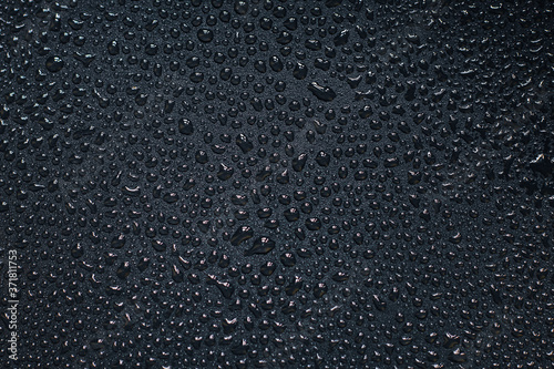 Water droplets on black background. Close-up photo of small water drops on black background.