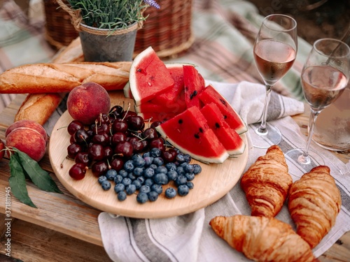 Summer picnic in nature with watermelon, croissants and two fujeriros wine.
