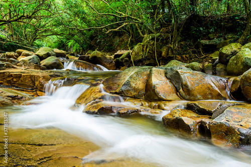 Creek or stream water flowing past rocks and stones in Taiwan photo