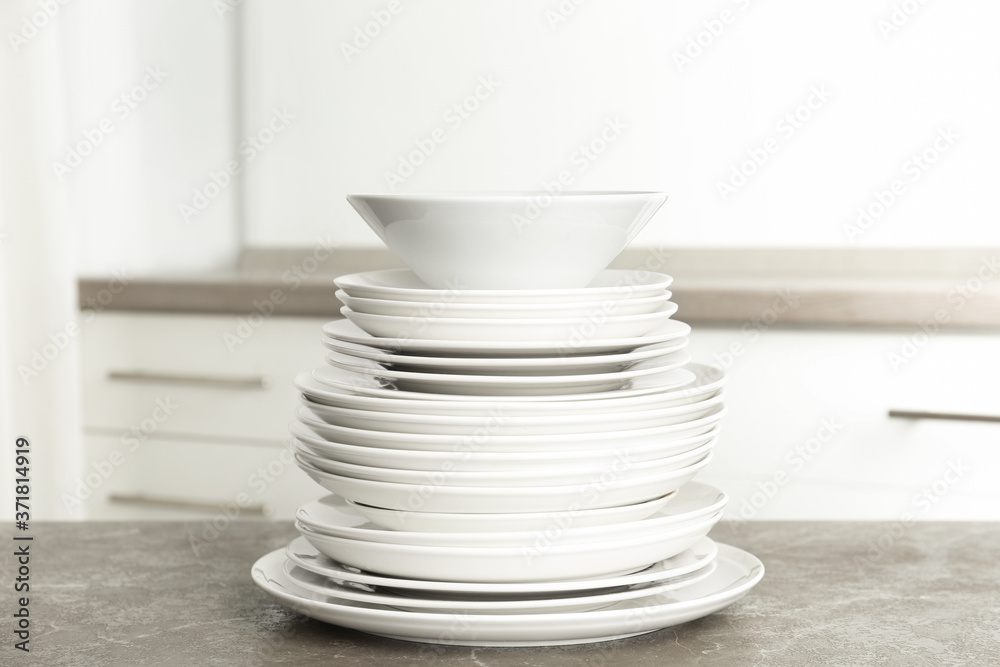 Stack of clean plates on marble table in kitchen Stack of clean plates on marble table in kitchen