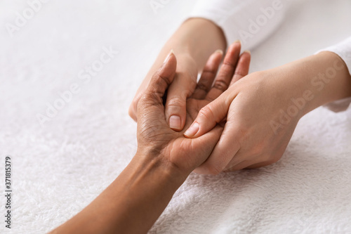 Acupuncture hand massage for black woman at spa photo