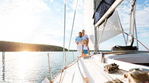 Family Relaxing On Yacht Enjoying Boat Ride Standing Outdoor, Panorama © Prostock-studio