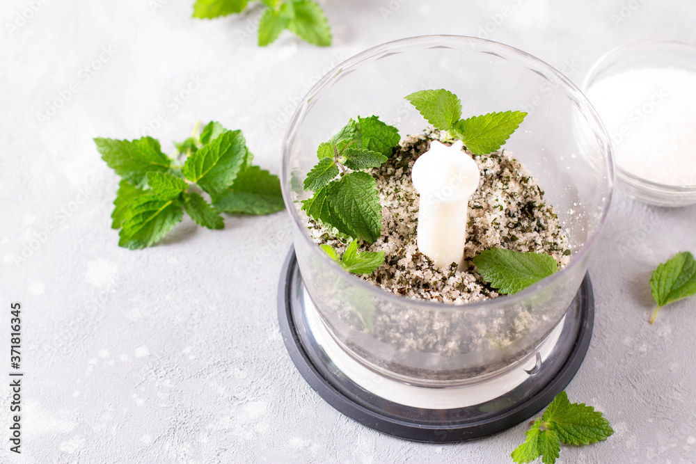 Homemade sugar scrub with chopped mint leaves in blender. Homemade sugar scrub with chopped mint leaves in blender.
