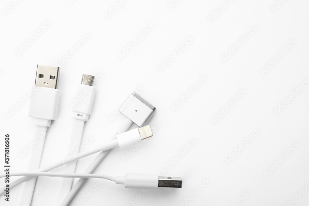 Charge cables on white background, top view. Modern technology Charge cables on white background, top view. Modern technology