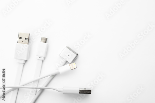 Charge cables on white background, top view. Modern technology
