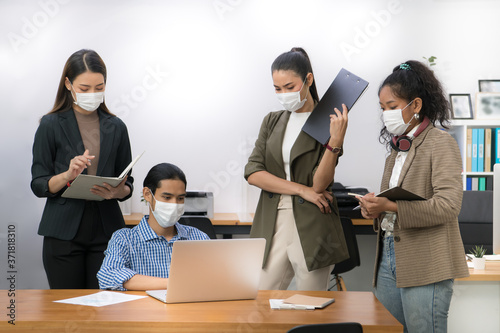 Wallpaper Mural Asian office workers wearing face masks working in the new normal office and doing social distancing during coronavirus COVID-19 pandemic Torontodigital.ca