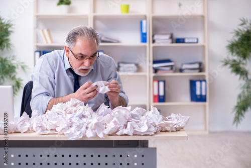 Old businessman rejecting new ideas with lots of papers
