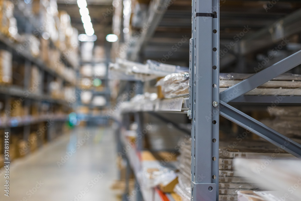Modern warehouse with goods on collapsible metal shelves. Blurred, focus with shallow depth of field.
