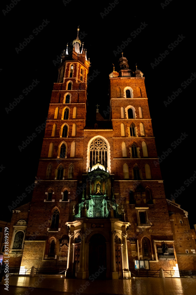 Old city center view with Adam Mickiewicz monument and St. Mary's Basilica in Krakow at night