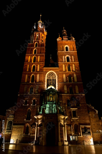 Old city center view with Adam Mickiewicz monument and St. Mary's Basilica in Krakow at night