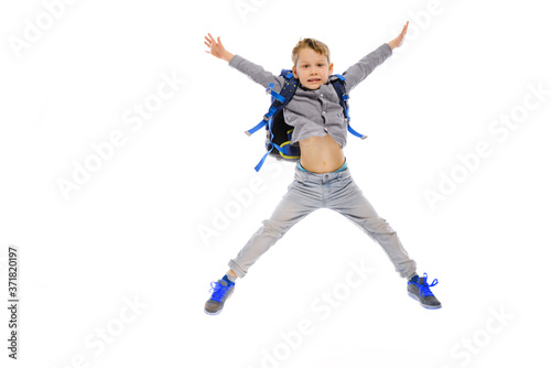 jumping Child with backpack sits on the floor - isolated