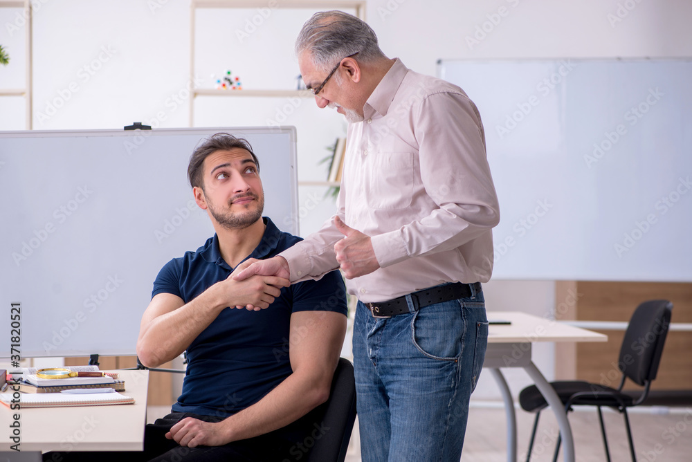 Fototapeta premium Old teacher and young male student in the classroom