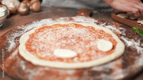Adding mozzarella cheese on a pizza dough in 4K