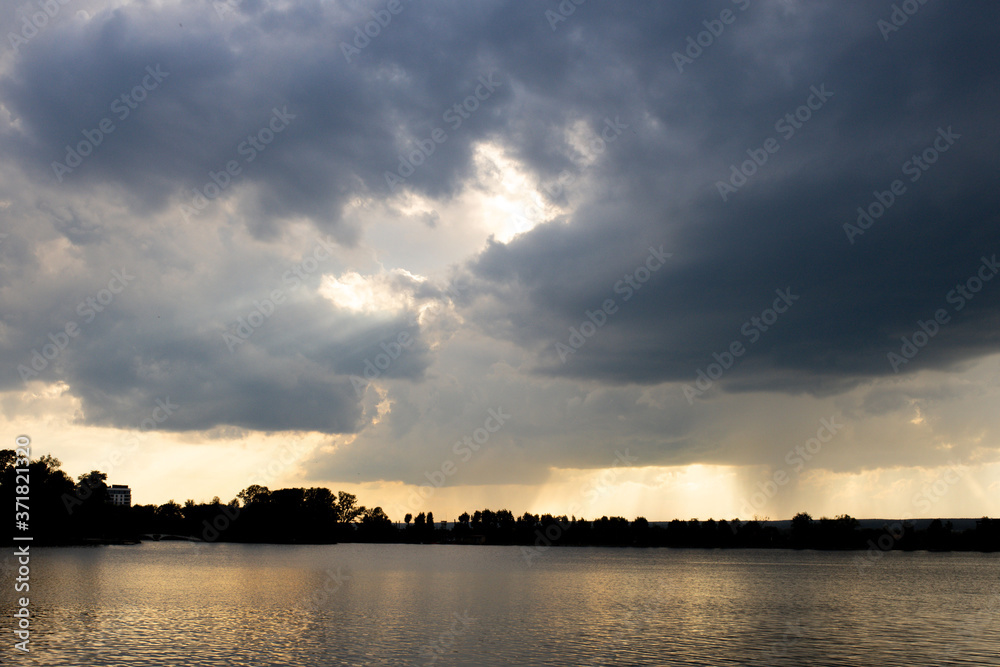 Aerial sunset or sunrise sky over a lake framed with scattered clouds varying in color.