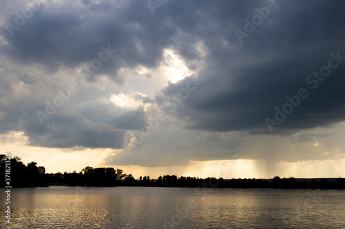 Aerial sunset or sunrise sky over a lake framed with scattered clouds varying in color. © volody10