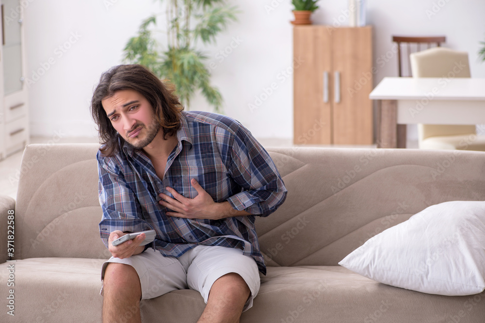 Fototapeta premium Young man suffering at home