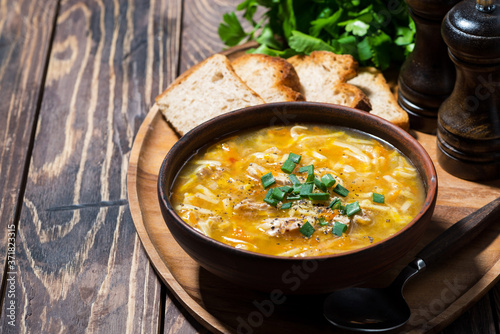 chicken soup with egg noodles on wooden background photo