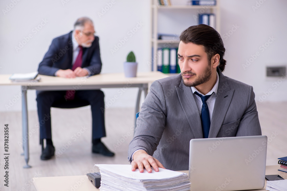 Fototapeta premium Old boss and his young assistant working in the office