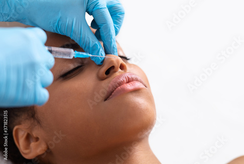 African american lady having filling injections for nose zone
