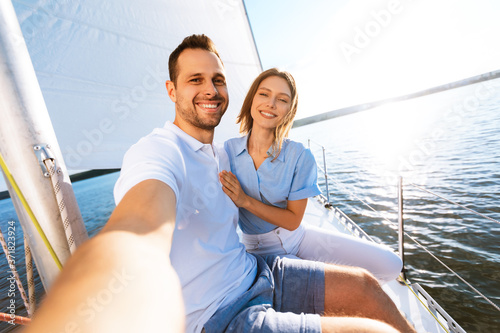 Couple Making Selfie Sitting On Deck Enjoying Sailing At Seaside © Prostock-studio