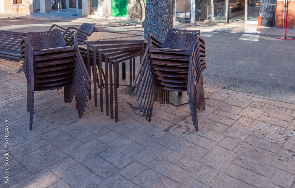 Brown plastic chairs stacked next to outdoor tables