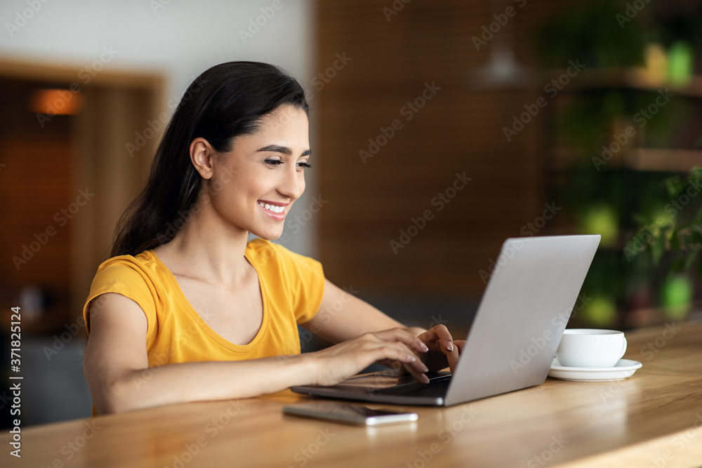 Smiling arab girl freelancer chatting with client, cafe interior Smiling arab girl freelancer chatting with client, cafe interior