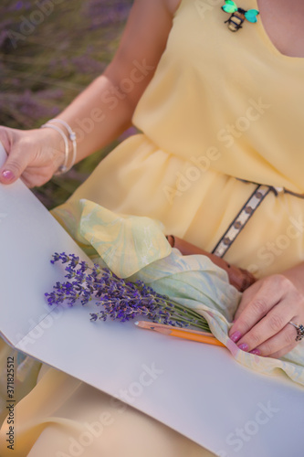 Woman in yellow dress paints in the open air in lavender field