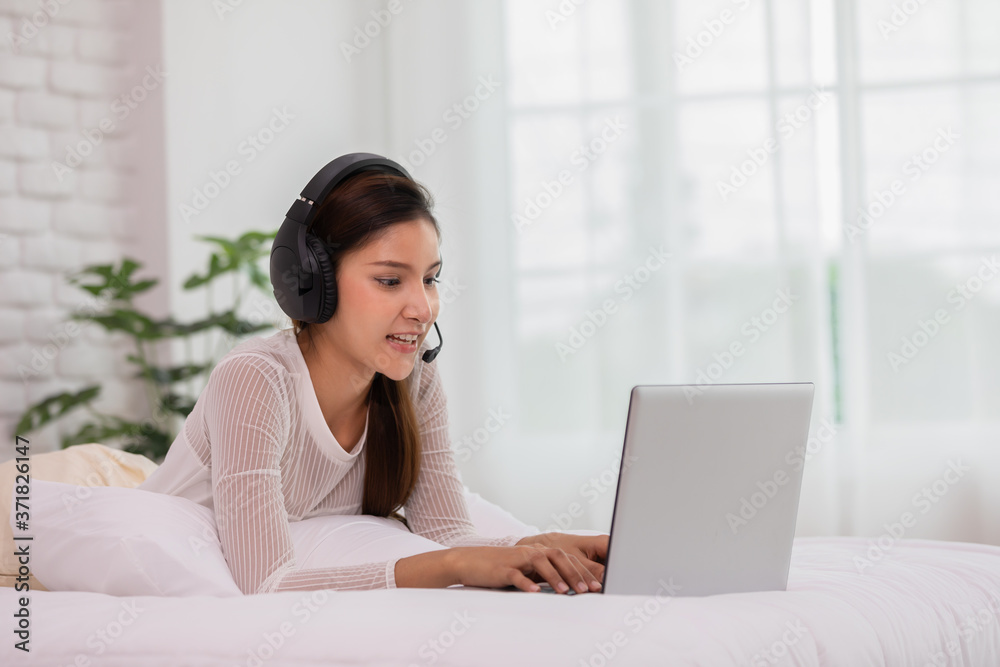 Asian woman wearing earphone and meeting in VDO call conferennce or learning online course due Covid-19 Virus Pandemic at home,Video conference work from home concept Asian woman wearing earphone and meeting in VDO call conferennce or learning online course due Covid-19 Virus Pandemic at home,Video conference work from home concept