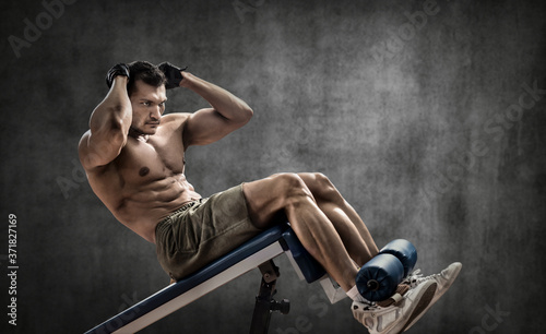 man bodybuilder perform exercise on prelum abdominale on bench