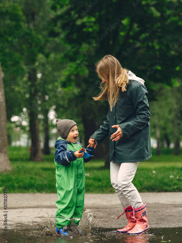 Family in a rainy park. Kids in a puddle. Child having fun outdoors. Family in a rainy park. Kids in a puddle. Child having fun outdoors.