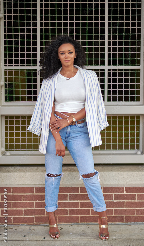 often Descriptive Go through Stunning young black woman poses near brick wall wearing blue jeans white  shirt and blazer - fashion and business casual Stock Photo | Adobe Stock