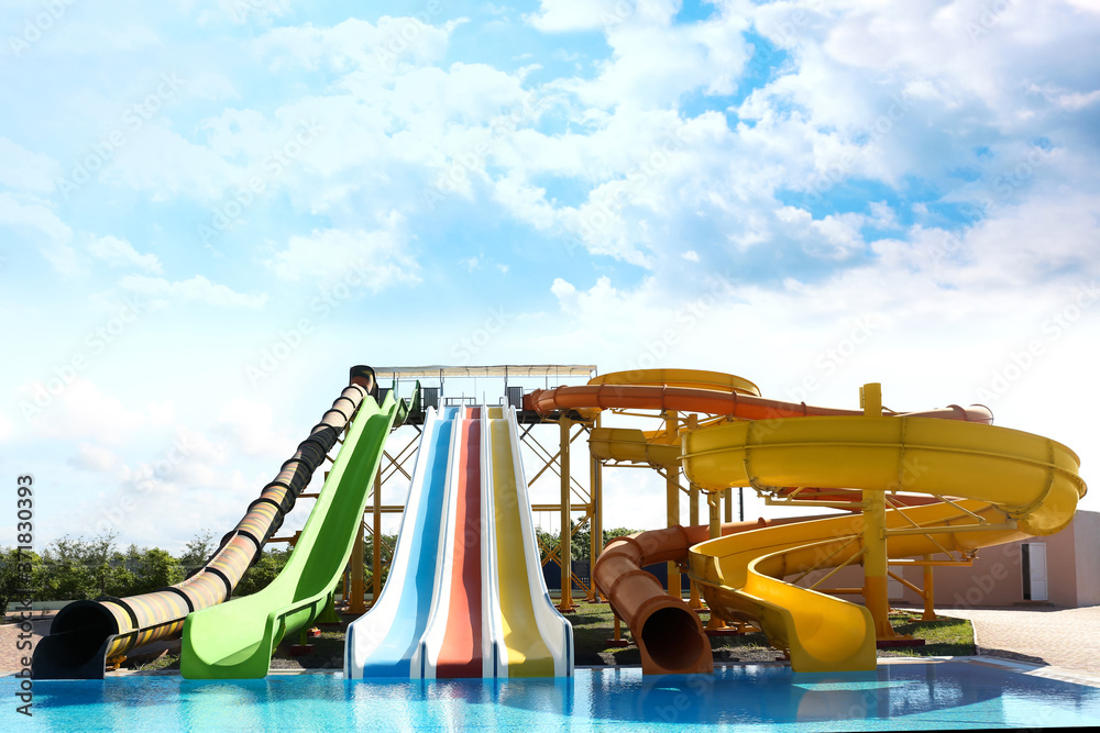 Different colorful slides in water park on sunny day Different colorful slides in water park on sunny day