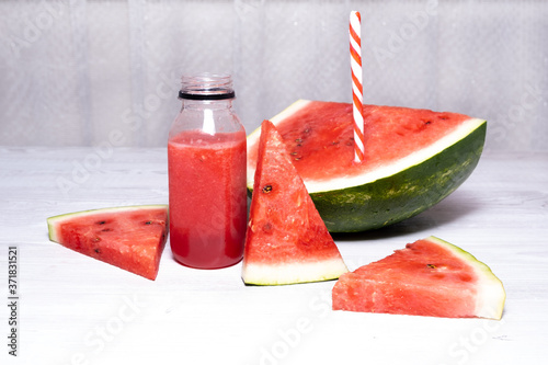 vitamin watermelon smoothie and slices of fresh red watermelon on a white wooden table background. copy space