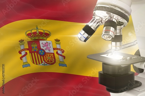 Microscope on Spain flag background - science development concept. Research in pharmaceutical industry or cell life 3D illustration of object