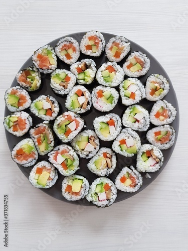 sushi platter on grey plate on white wooden table